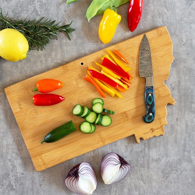 Totally Bamboo Montana State Shaped Cutting Board, Art by Fish Kiss | State charcuterie board with colorful hand-drawn map artwork. Smooth reverse side for food prep. Hang tie for wall display.