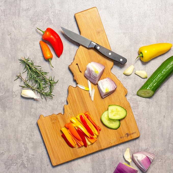 Totally Bamboo Idaho State Shaped Cutting Board, Summer Stokes Art | State charcuterie board with colorful hand-drawn landscape art. Smooth reverse side for food prep. Hang tie for wall display.